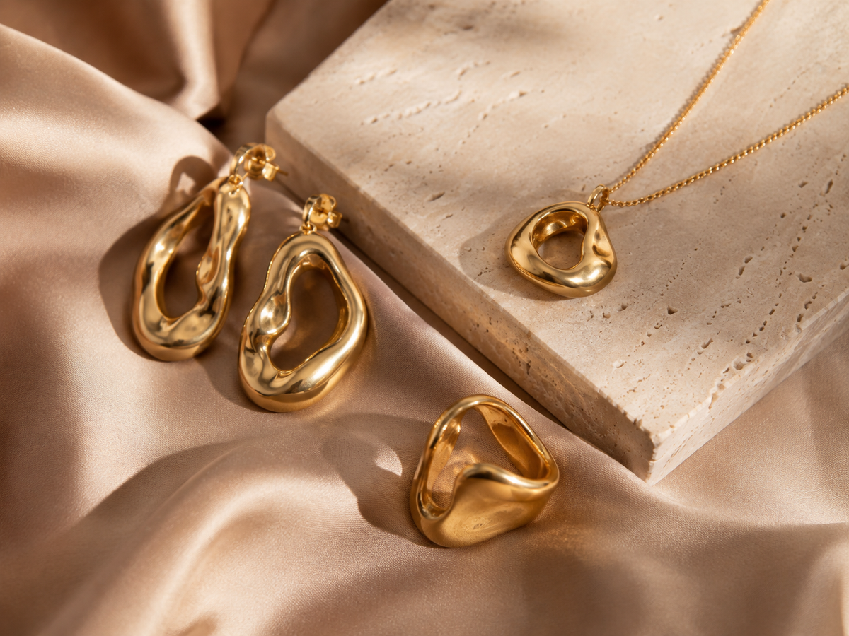 Gold-plated brass fashion jewelry on warm silk and stone