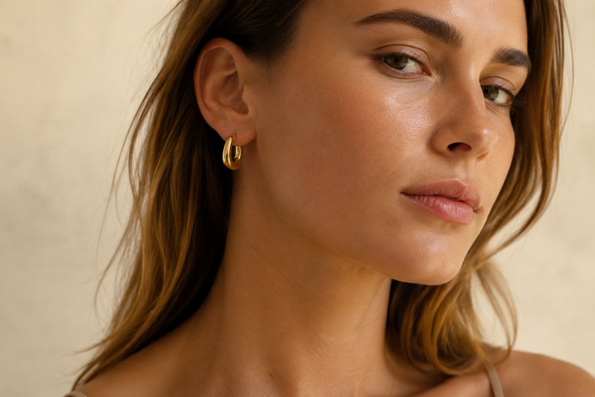 Gold stainless steel hoop earrings worn by a model for a wholesale earring collection