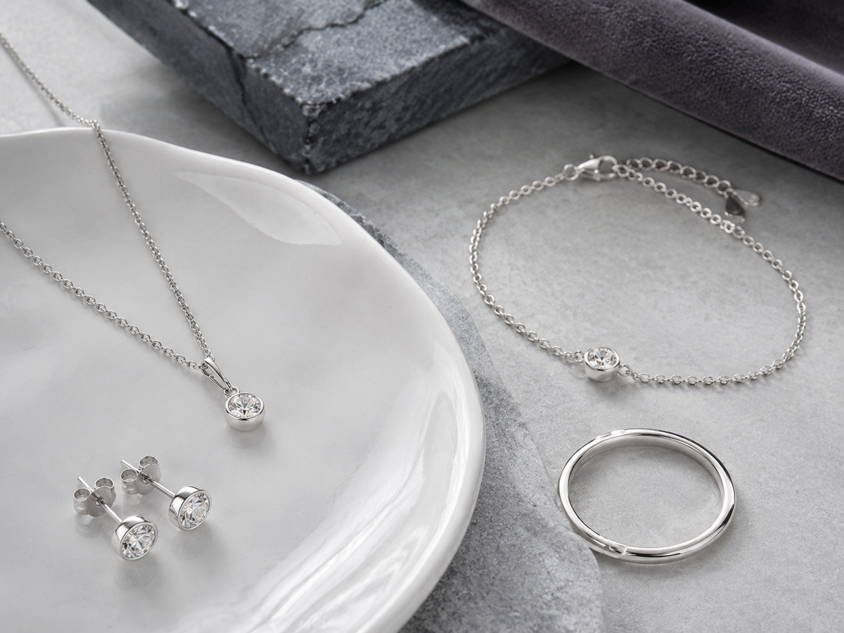Delicate 925 sterling silver wholesale jewelry collection on white ceramic and grey stone