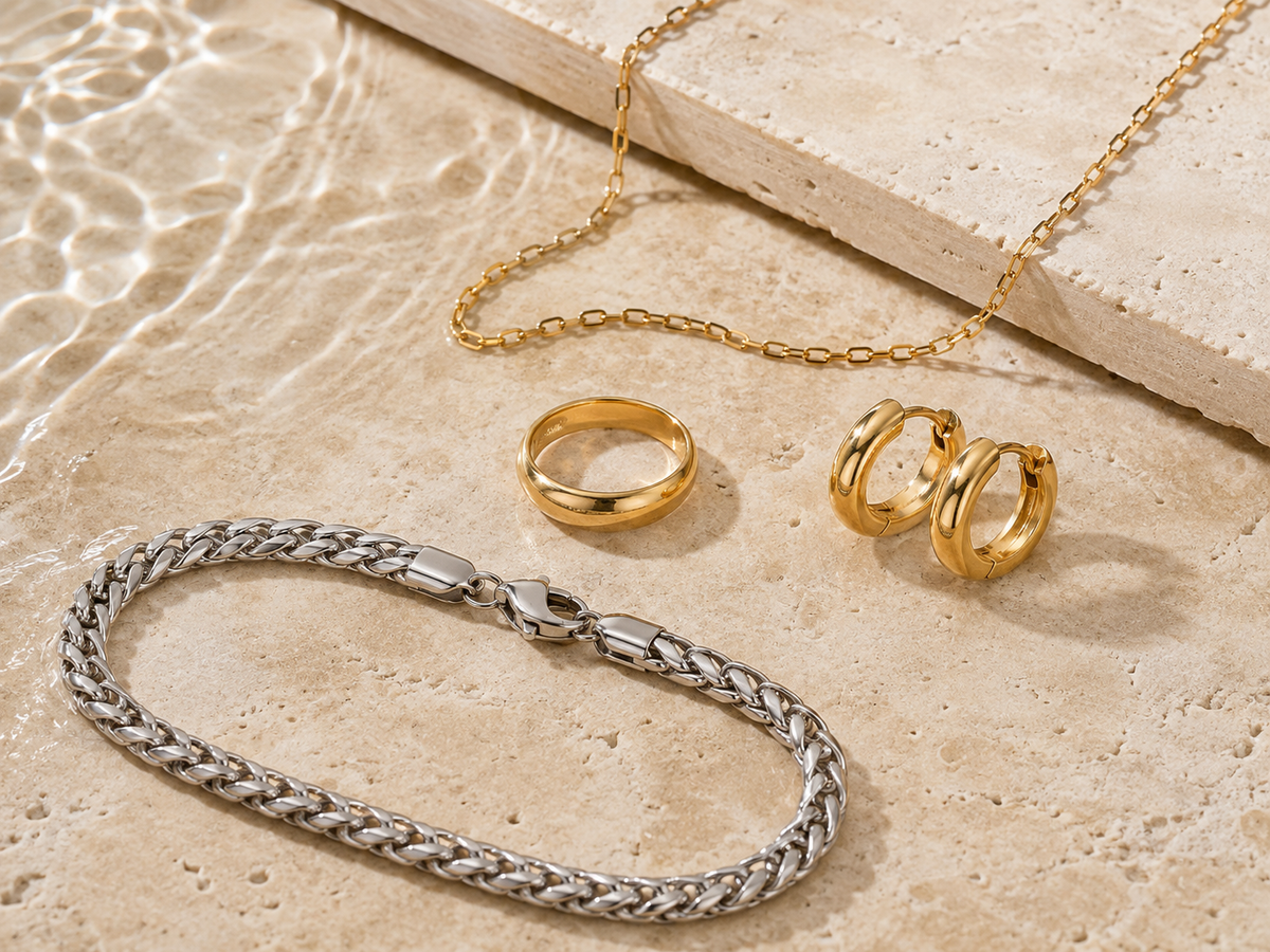 gold-plated and natural-finish stainless steel wholesale jewelry assortment on warm stone