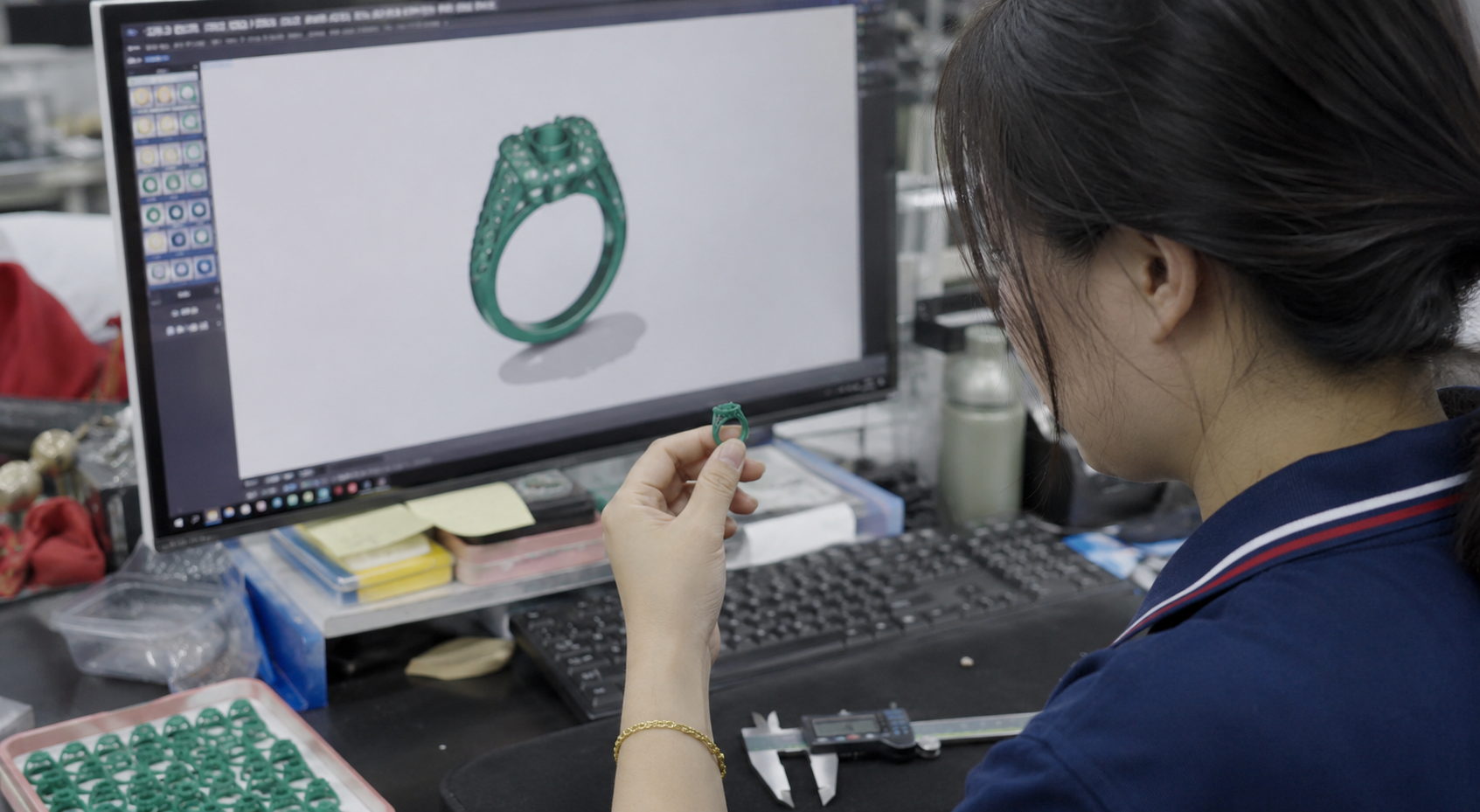 Chinese jewelry CAD designer reviewing a custom ring design and wax model