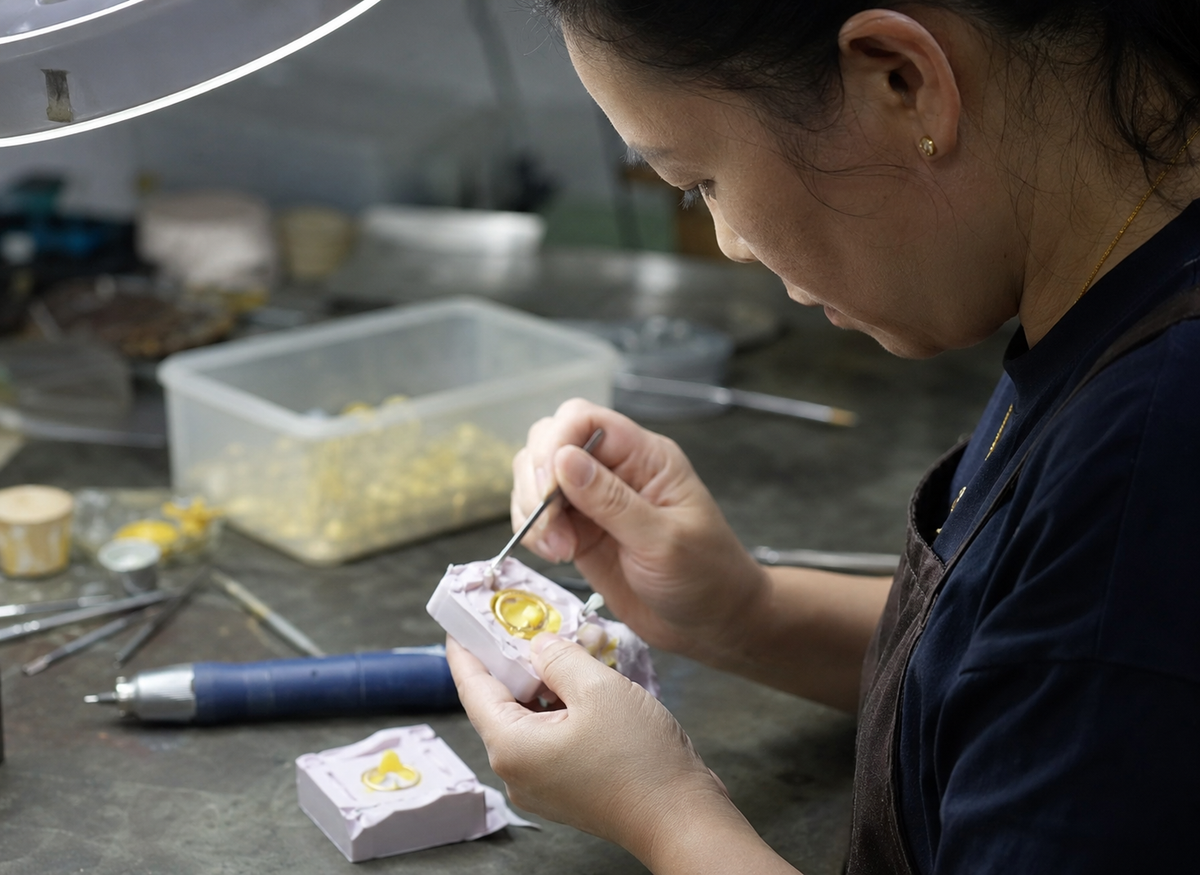 Chinese jewelry technician carefully opening a rubber mold for custom jewelry casting